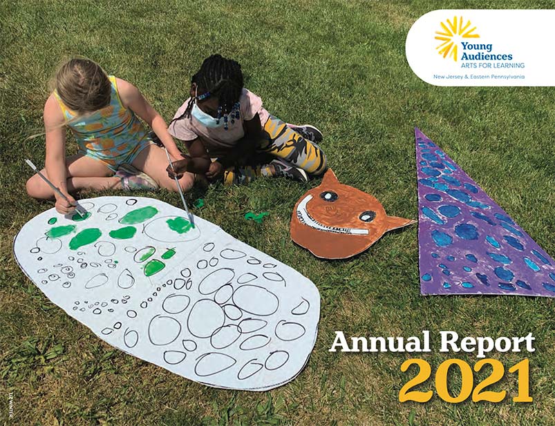 Young Audiences 2021 Annual Report Cover - students sitting on grass painting on cardboard